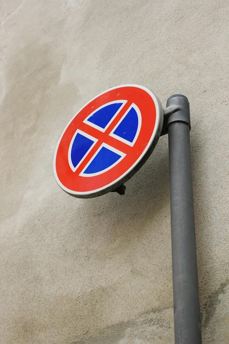 a red and blue street sign sitting on the side of a building