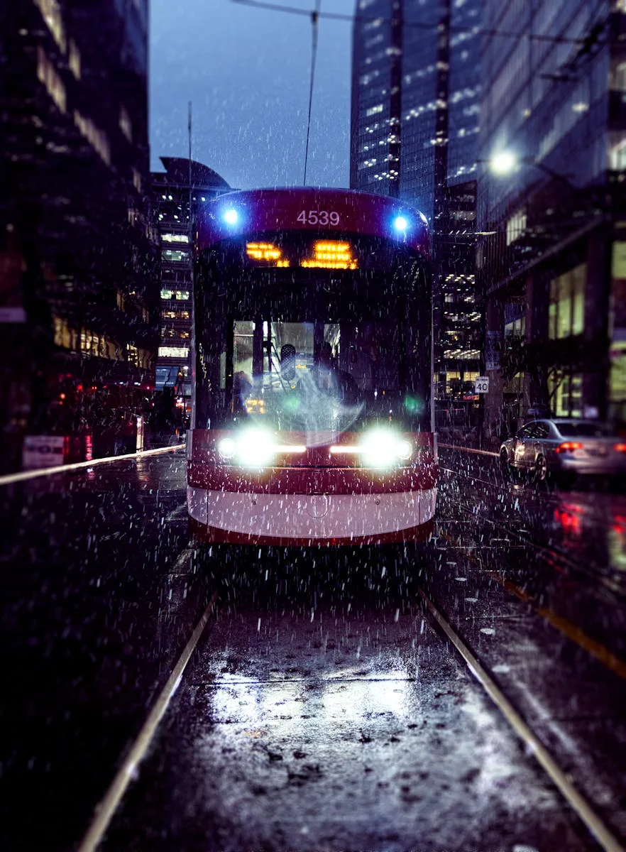 A Toronto streetcar traveling through downtown on a rainy night, highlighting urban transit.