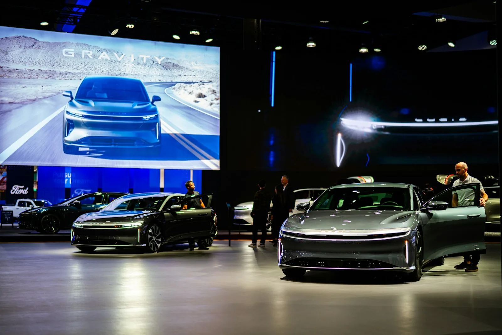 a group of people standing around a bunch of cars
