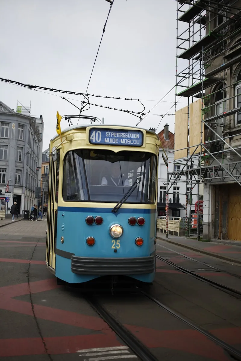 a blue and yellow trolley on a city street