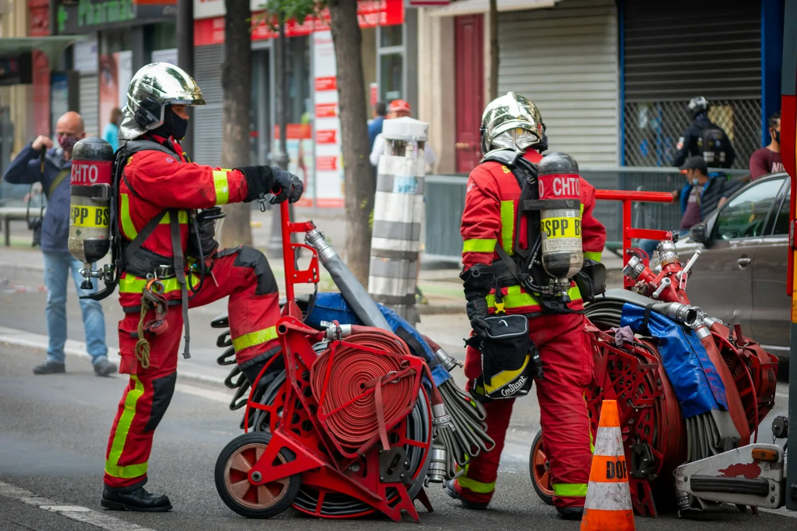 a couple of men in red suits pushing a motorcycle