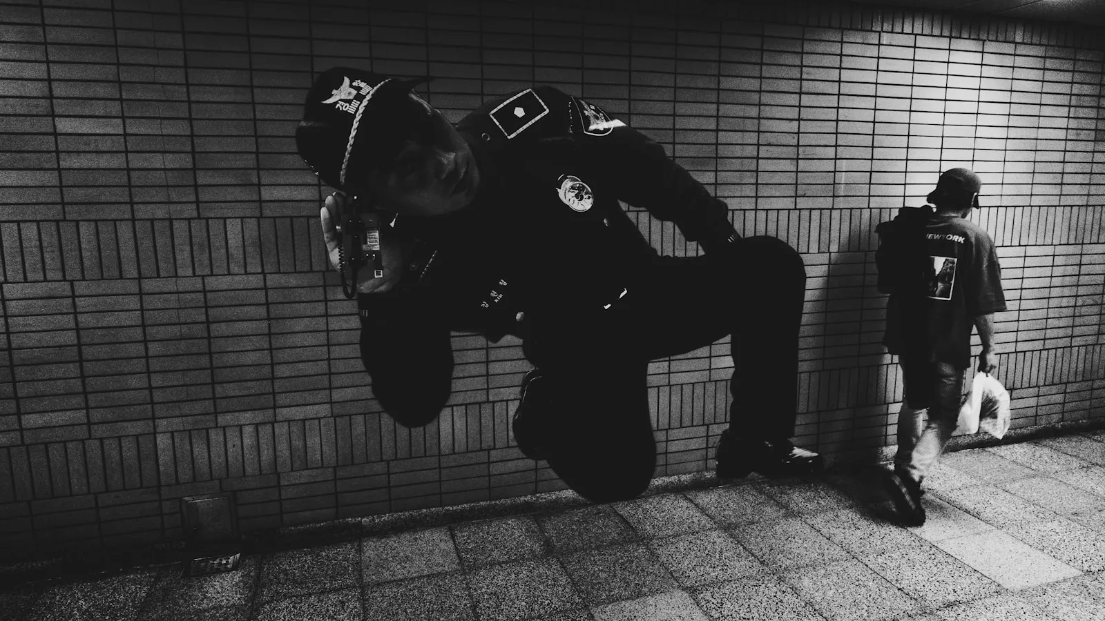 a man standing in front of a brick wall