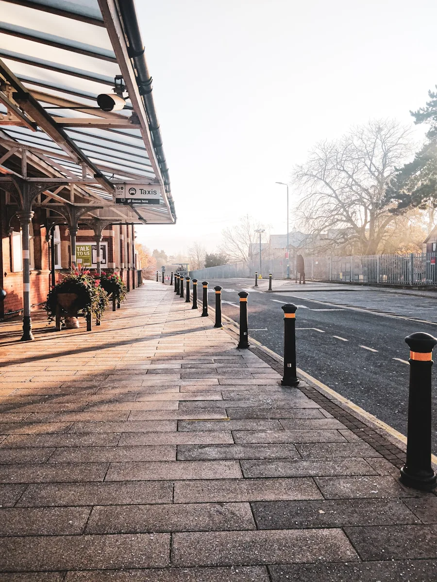 a sidewalk with black poles on both sides of it