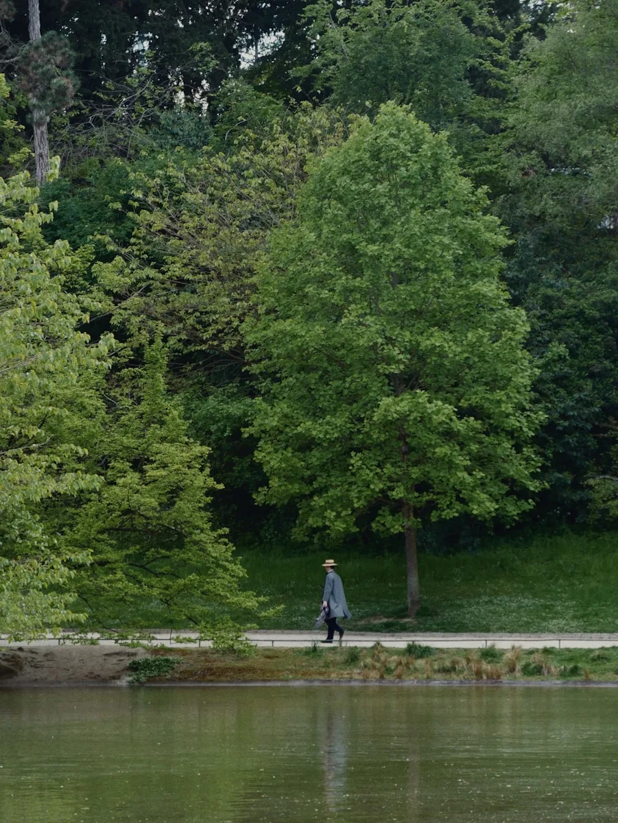 A person walking on a path next to a body of water