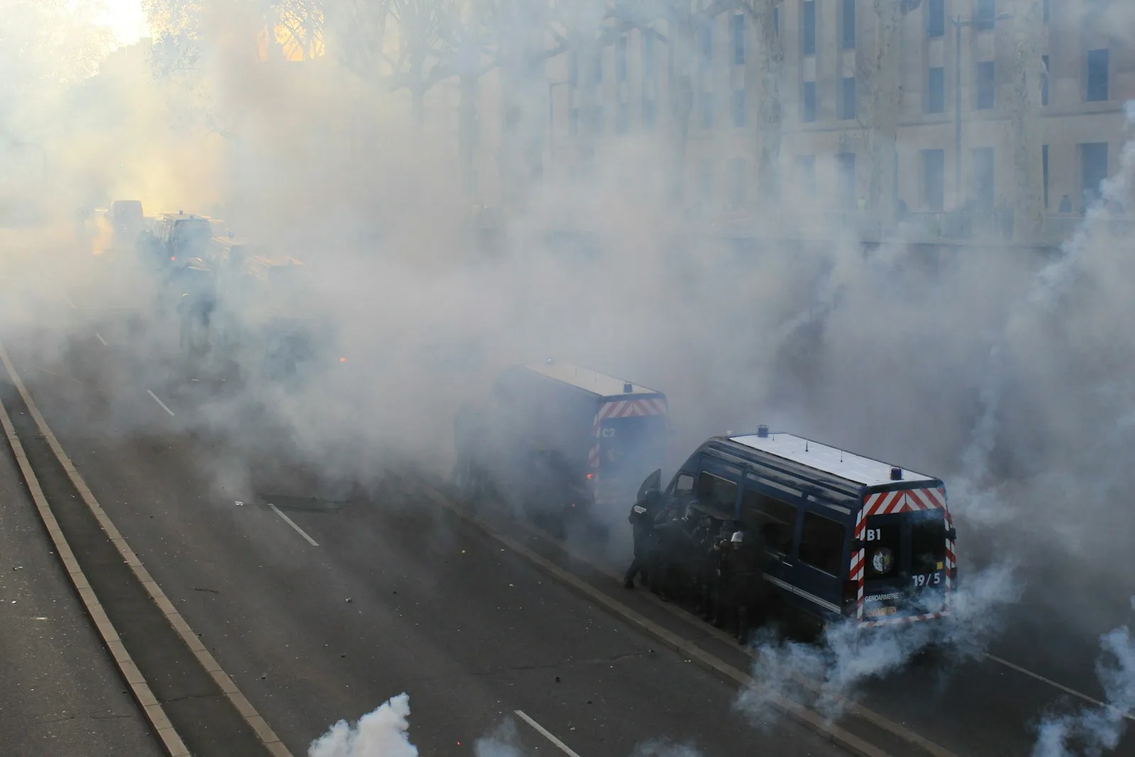 a street filled with lots of smoke next to a building