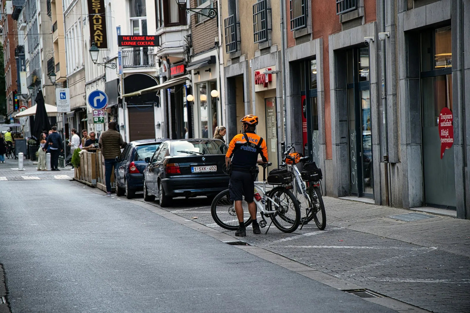 A man standing next to a bike on a city street