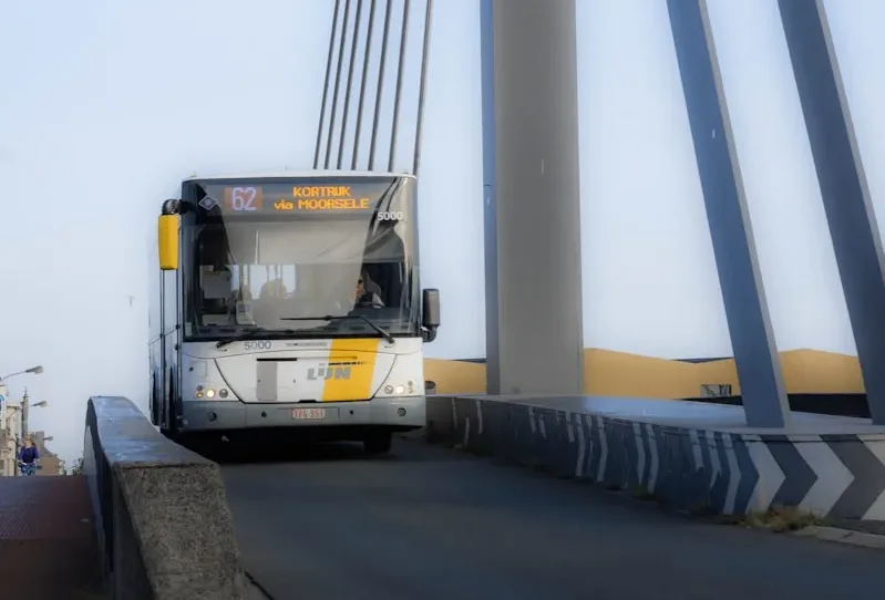 a bus driving over a bridge on a clear day