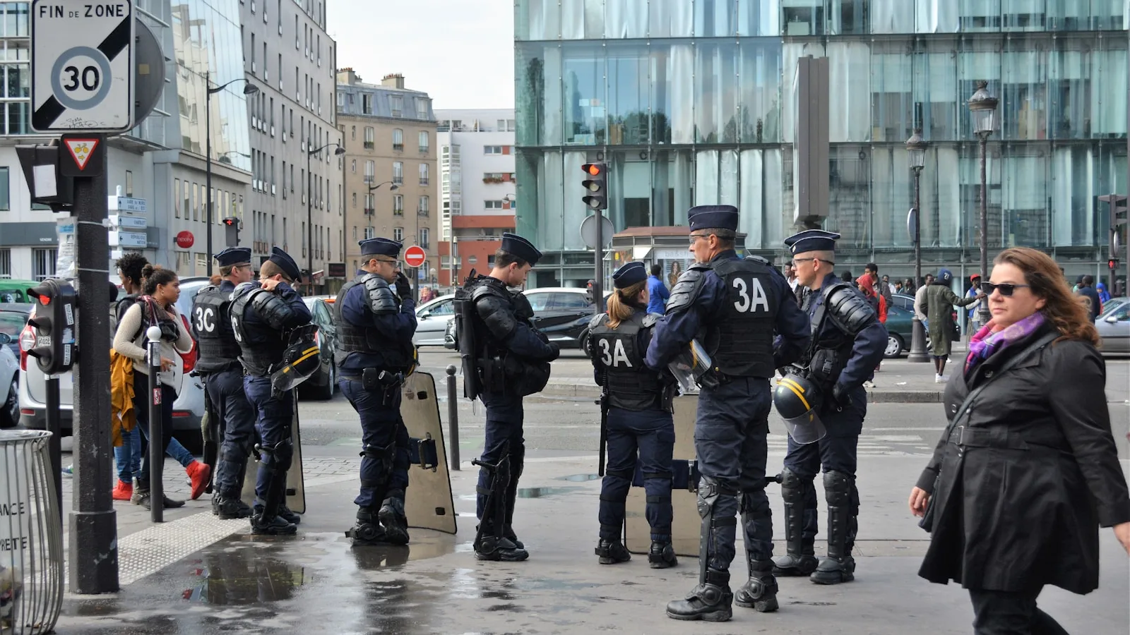 group of men in black and yellow uniform standing on road during daytime