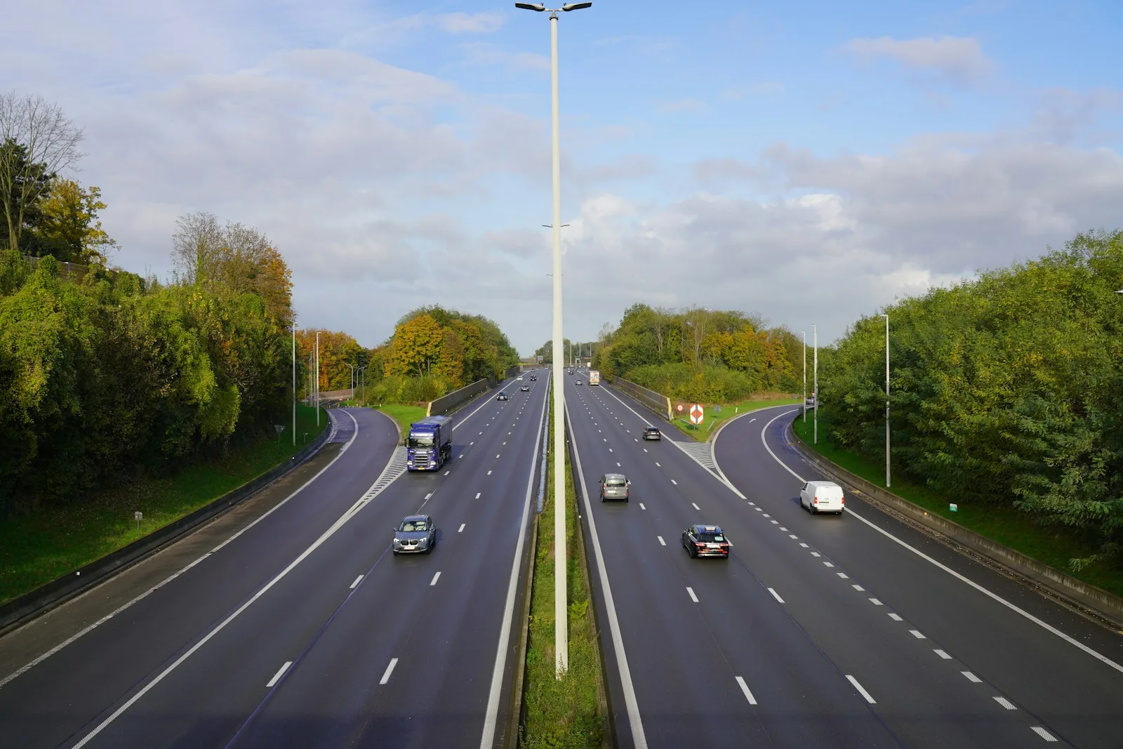 A highway with a bunch of cars driving down it
