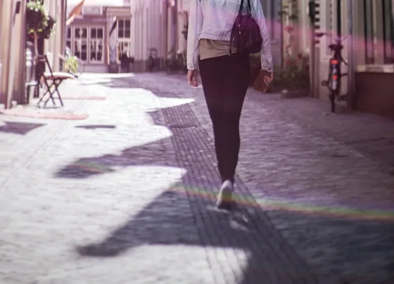 woman walking along buildings