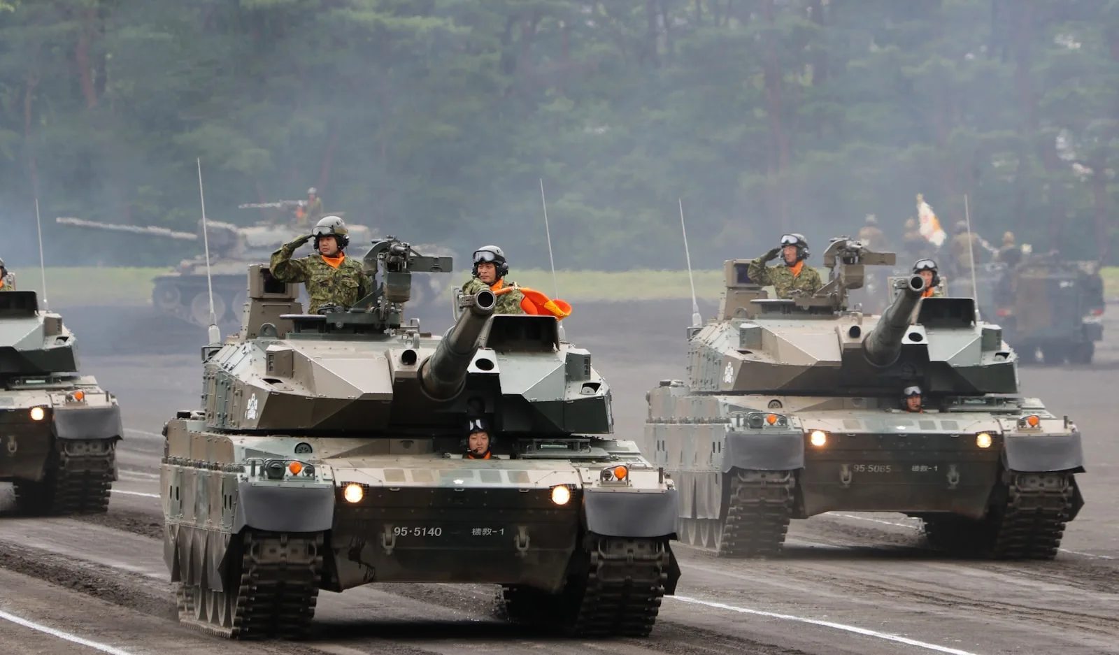 a group of military tanks driving down a road