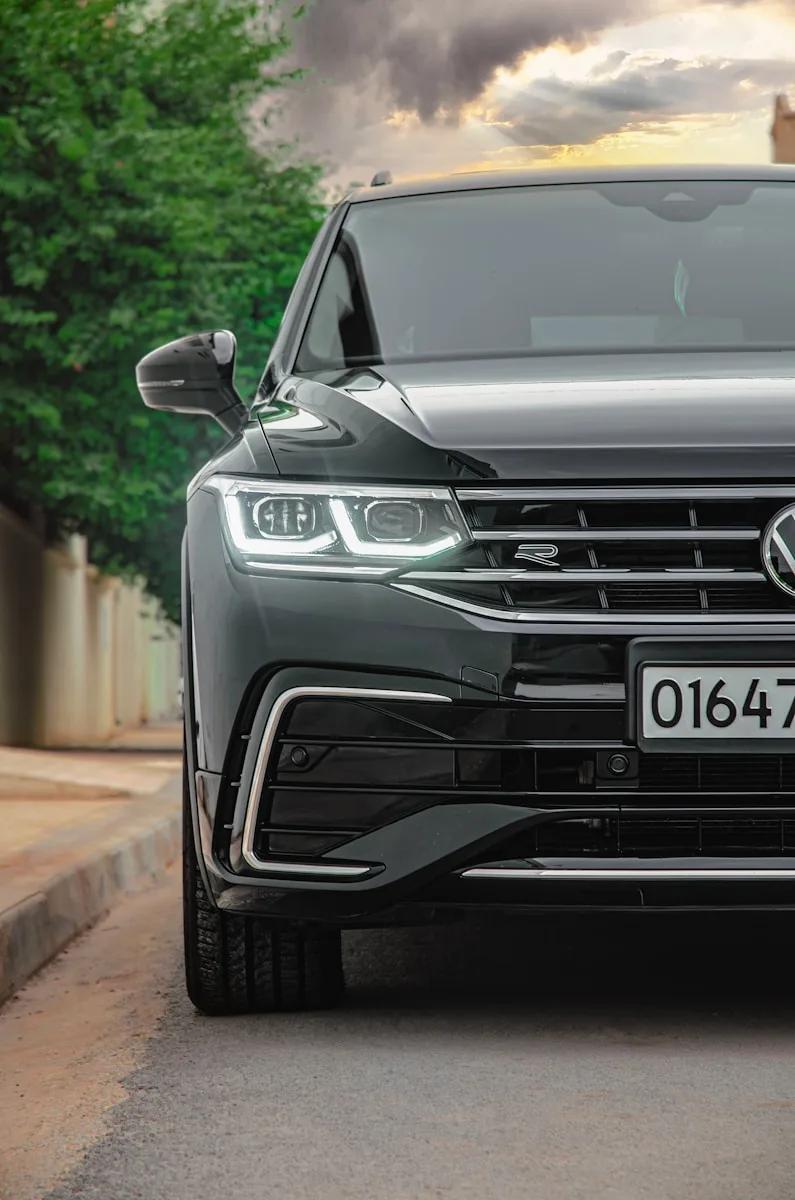 the front of a grey volkswagen tigua parked on the side of a road