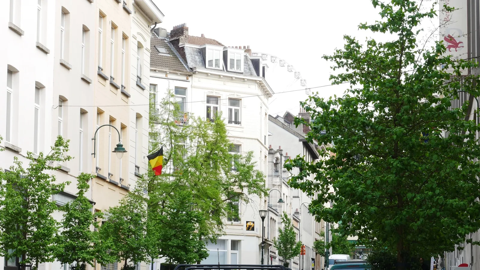 A city street lined with tall buildings and trees