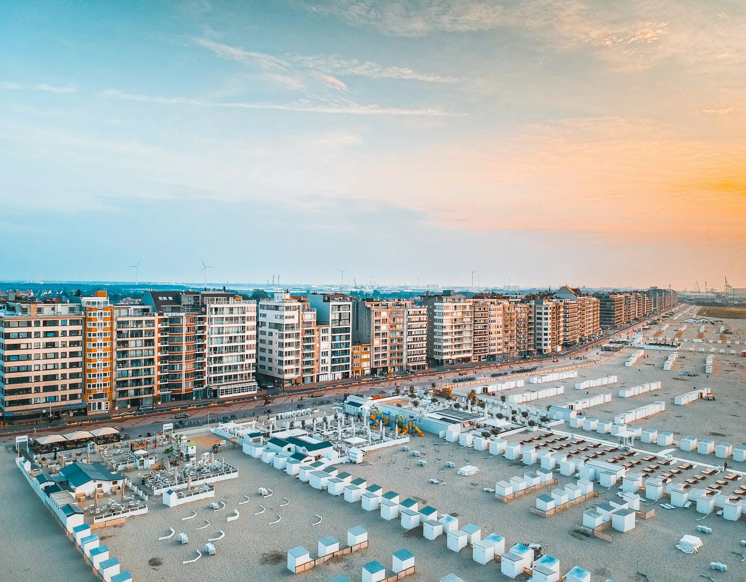 white and blue boats on sea shore near city buildings during daytime