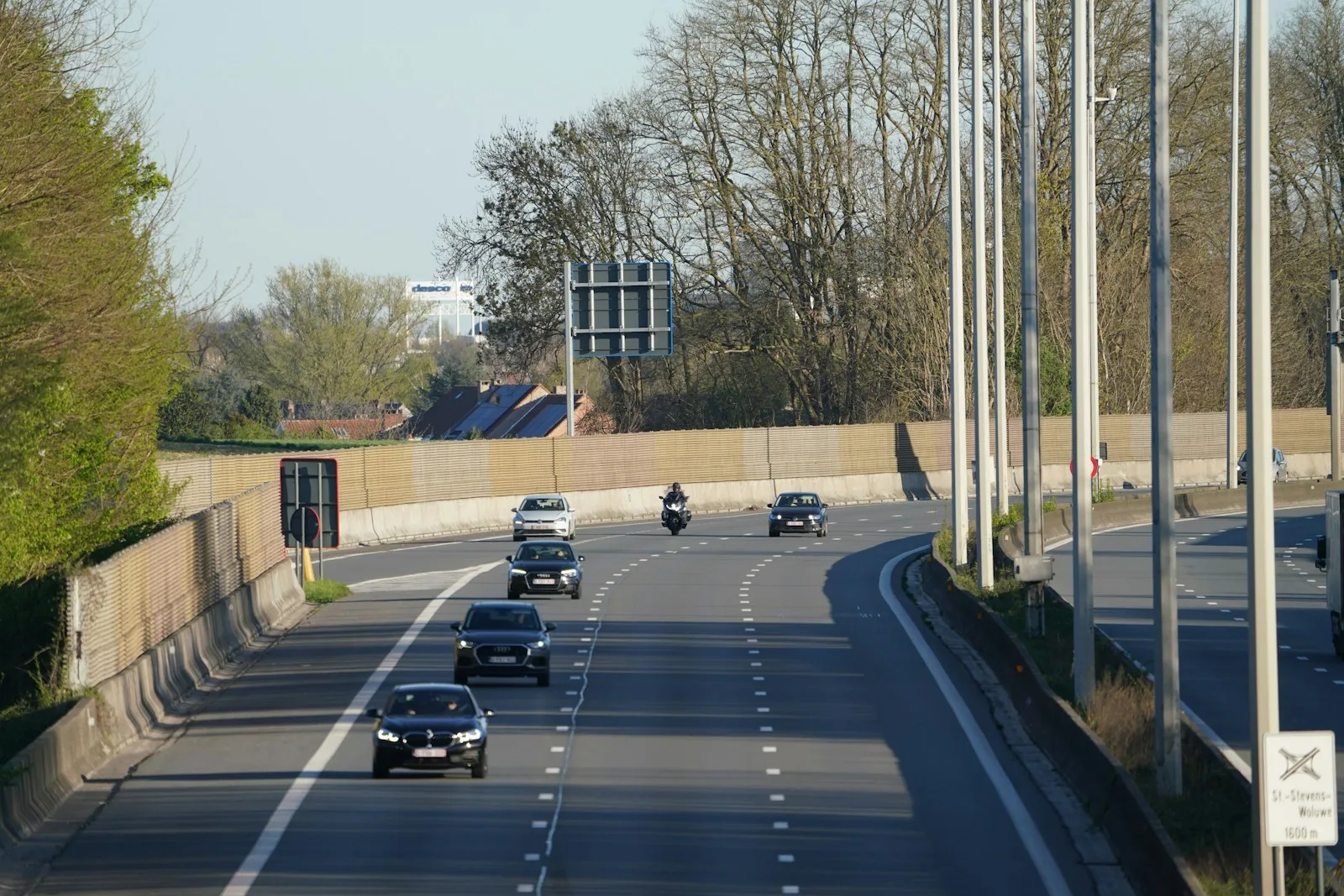 Cars and a motorcycle drive on the highway.