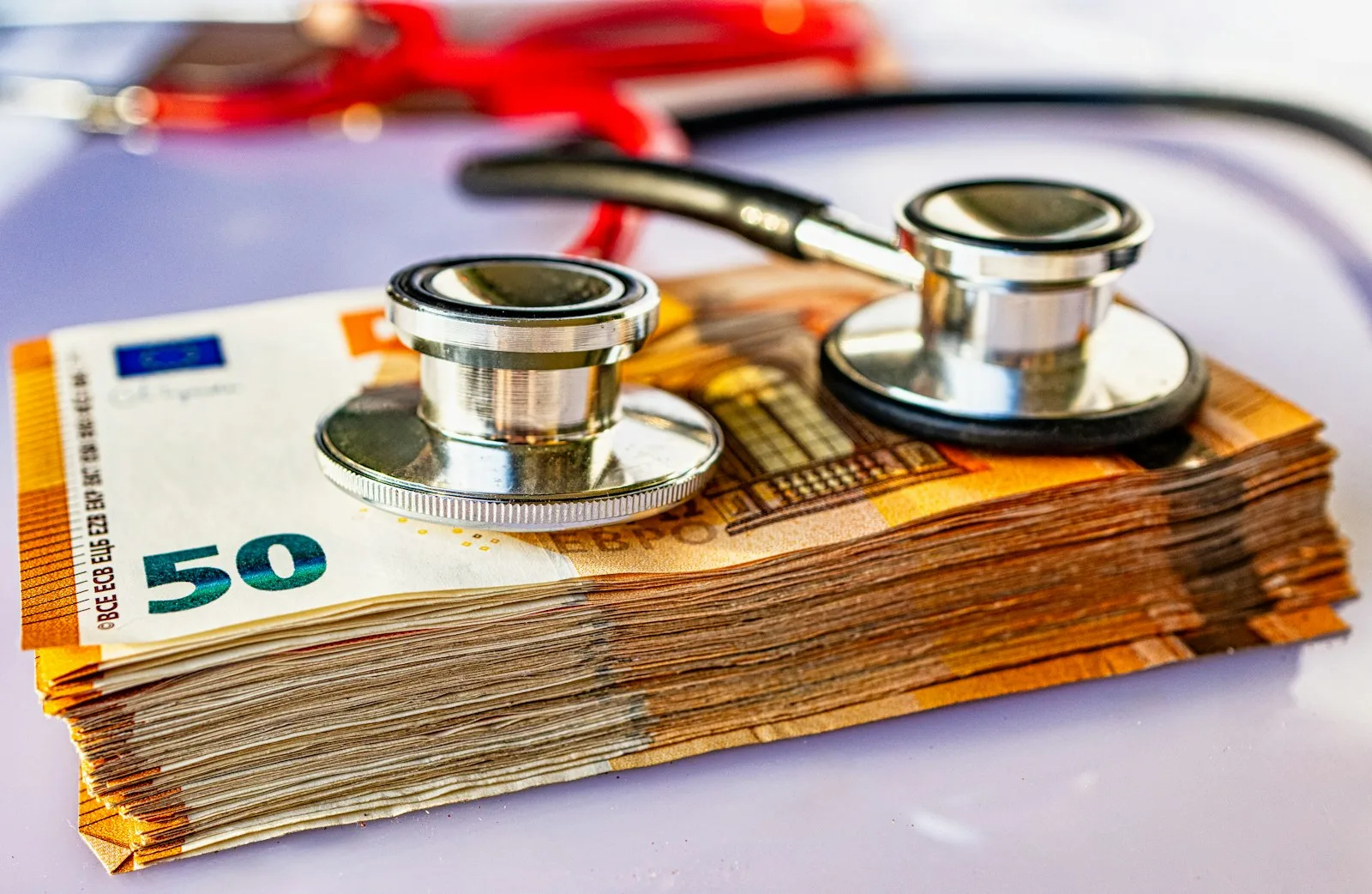 a pile of money with a stethoscope on top of it