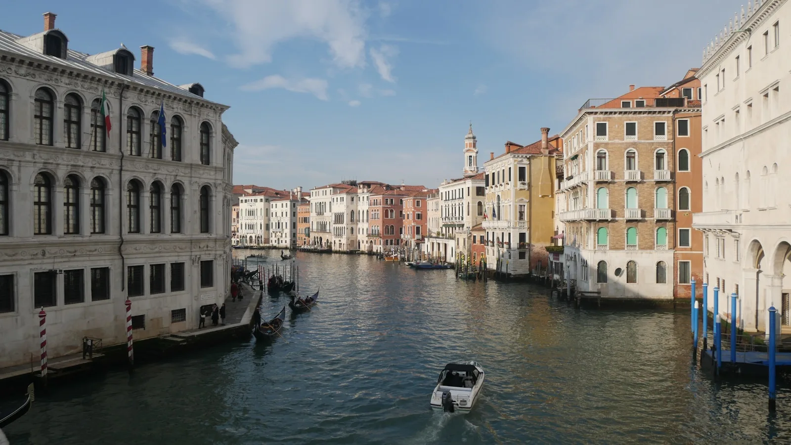 a boat traveling down a river next to tall buildings