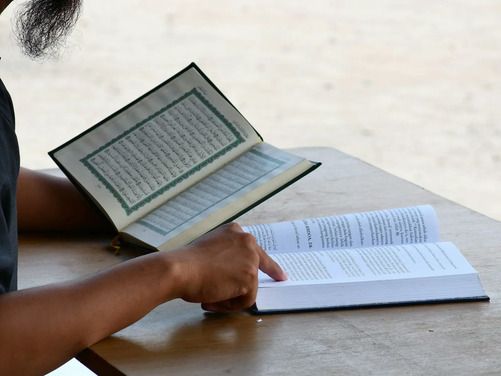 a person sitting at a table with an open book