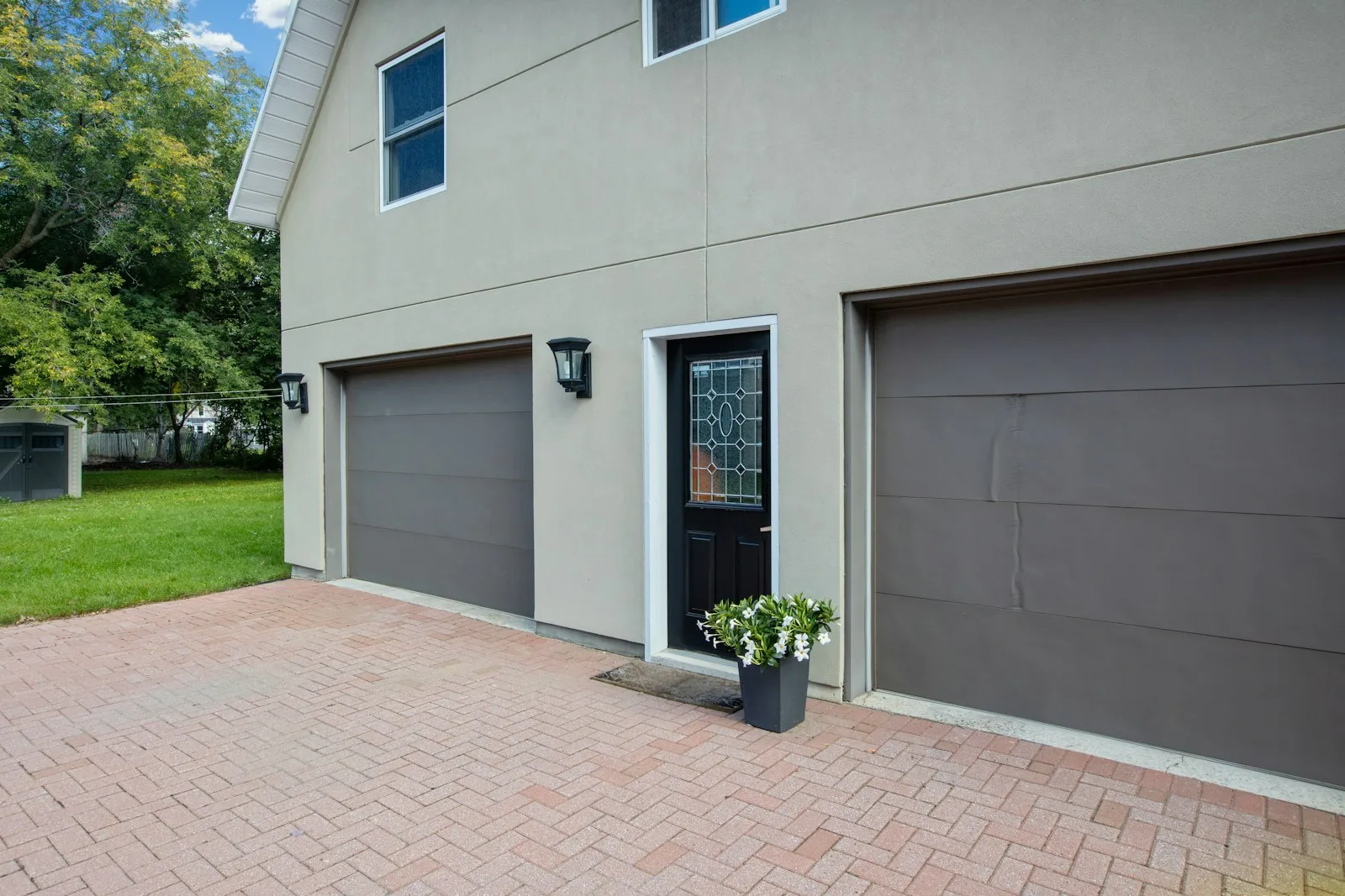 a house with two garage doors and a planter