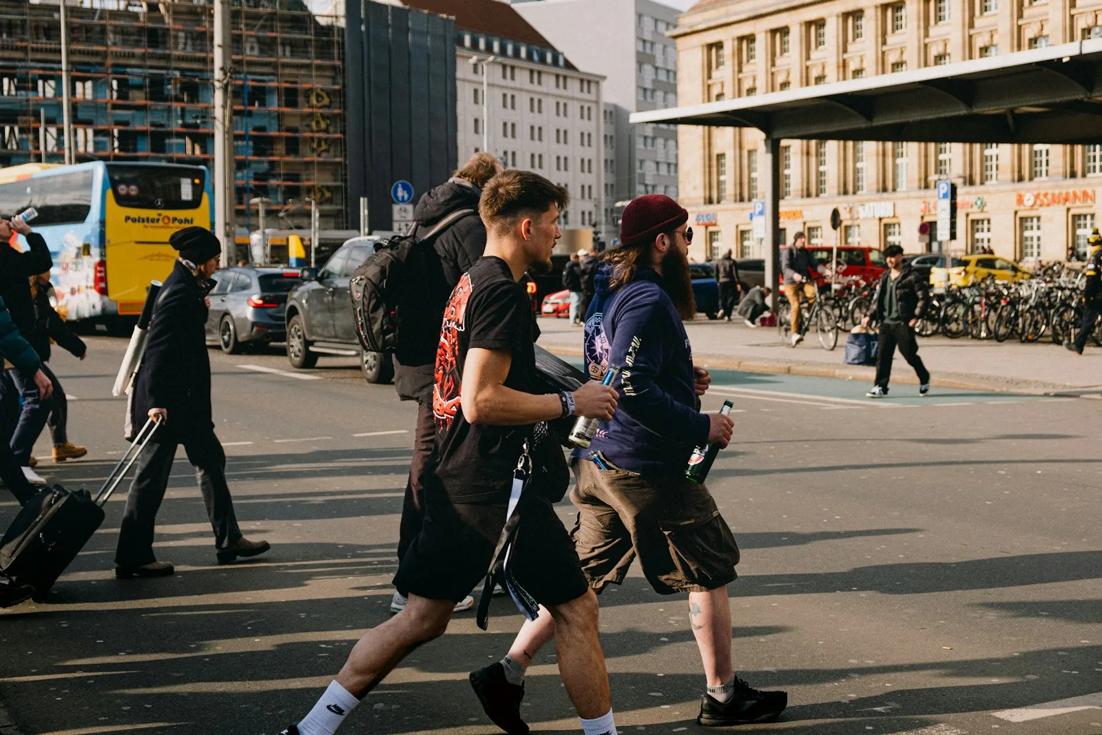 People are crossing a city street at a crosswalk.