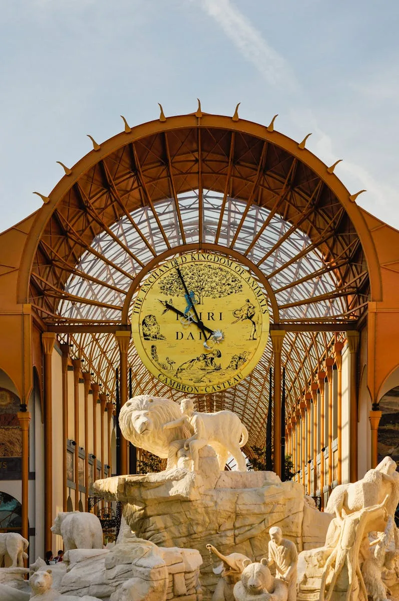 Stunning architectural entrance at Pairi Daiza Zoo featuring stone sculptures and a grand clock.