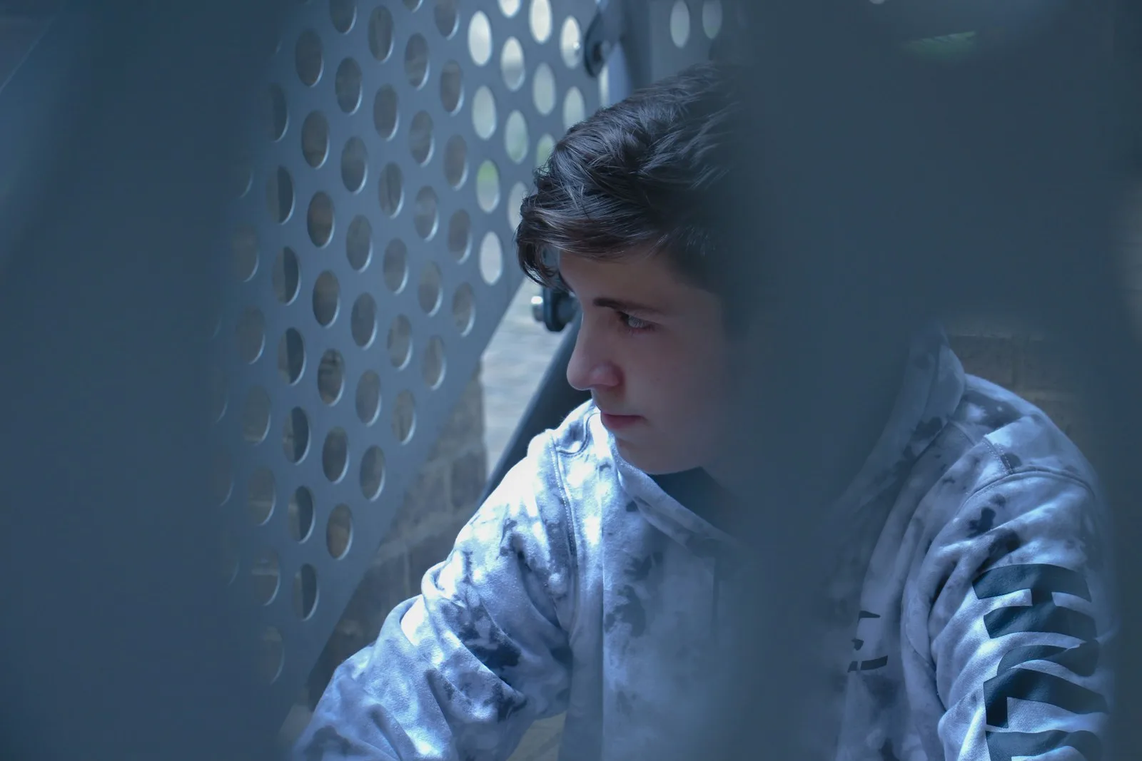 man in black and white hoodie beside white grill