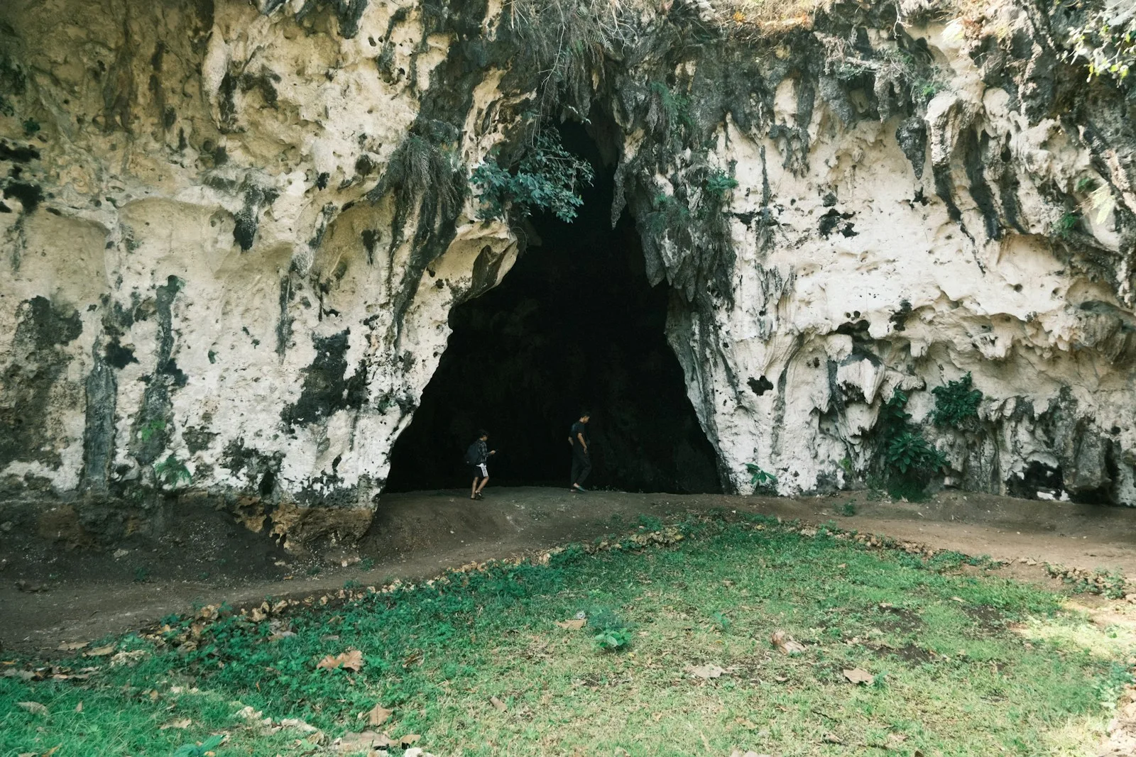 A person standing in a cave with a bike