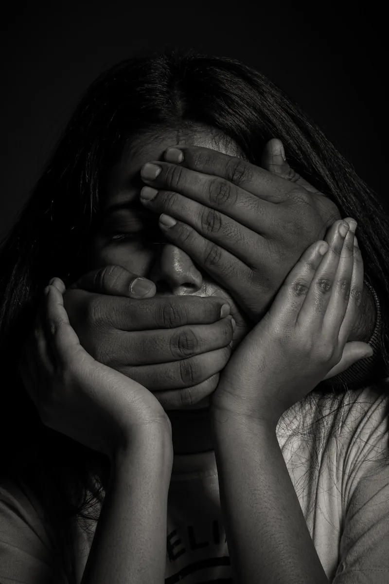 grayscale photo of woman covering her face with her hands