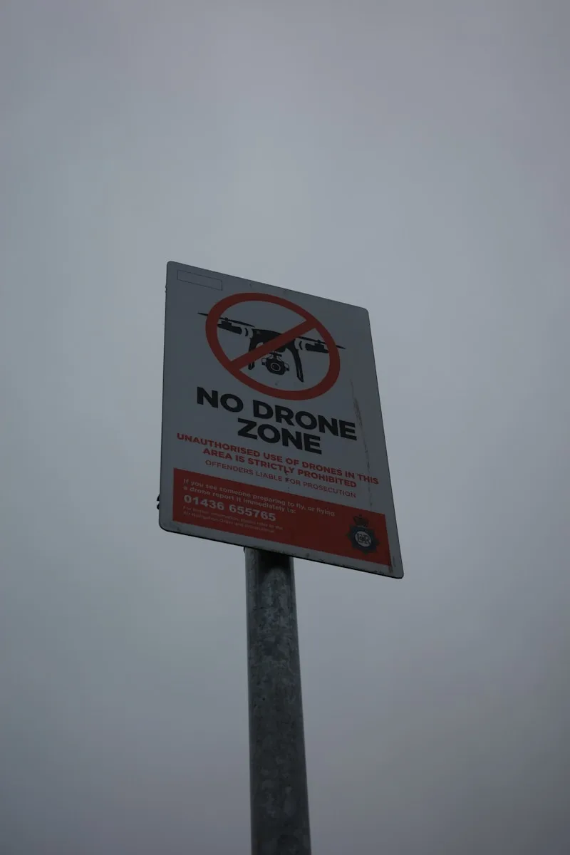 a no drone zone sign on a pole