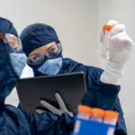 a person in a mask using a laptop