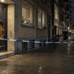Uszkodzone drzwi budynku mieszkalnego w Antwerpii nocą