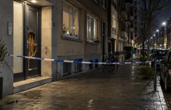 Uszkodzone drzwi budynku mieszkalnego w Antwerpii nocą