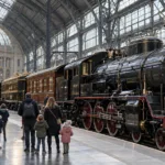 Zabytkowy parowóz i wagony na peronie dworca Antwerpen-Centraal, zwiedzający od tyłu