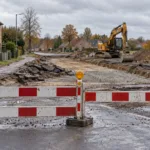 Zamknięte skrzyżowanie z barierami i robotami drogowymi we flamandzkiej wsi - wizualizacja