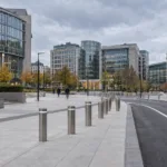 Przebudowany, pusty plac w dzielnicy europejskiej w Brukseli z betonową esplanadą, słupkami i pasem jezdni