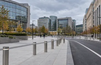 Przebudowany, pusty plac w dzielnicy europejskiej w Brukseli z betonową esplanadą, słupkami i pasem jezdni