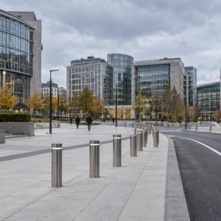 Przebudowany, pusty plac w dzielnicy europejskiej w Brukseli z betonową esplanadą, słupkami i pasem jezdni