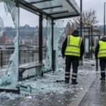 Zniszczona wiata przystanku tramwajowego i pracownicy oceniający szkody