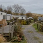 Przyczepy kempingowe i domki z tarasami na kempingu przy belgijskim wybrzeżu jesienią