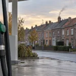 Stacja paliw z dystrybutorem na tle belgijskich domów szeregowych z kominami