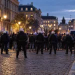 Kordon policji na brukowanej ulicy w centrum Brukseli o zmierzchu