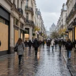 Witryny sklepów zasłonięte drewnianymi panelami przy deptaku handlowym w centrum Brukseli