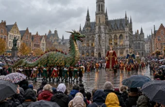 Parada z figurą zielonego smoka na rynku przed gotyckim ratuszem, tłum widzów z parasolami