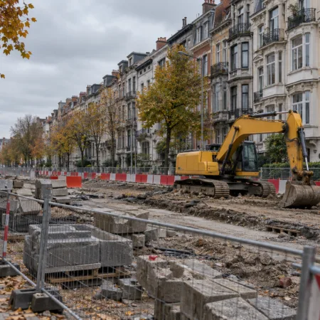 Roboty drogowe na szerokim bulwarze w Schaerbeek, ogrodzenia, bariery i koparka