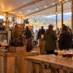 Festiwal piwa rzemieślniczego pod namiotem, kieliszki degustacyjne na drewnianym stole (wizualizacja SI)