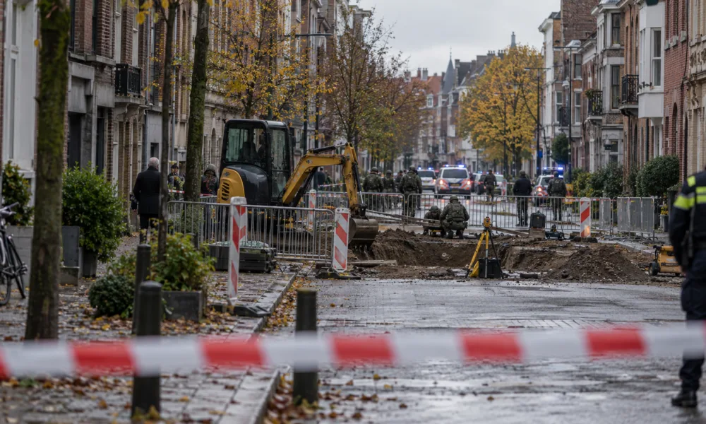Ulica w Antwerpii odgrodzona taśmą policyjną przy wykopie, w tle radiowozy i saperzy