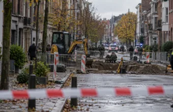 Ulica w Antwerpii odgrodzona taśmą policyjną przy wykopie, w tle radiowozy i saperzy