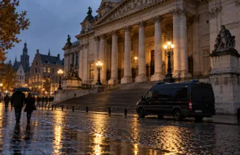 Gmach sądu w deszczowy jesienny wieczór, mokry bruk i radiowóz przed schodami