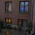 Tylna fasada ceglanego bloku mieszkalnego w Antwerpii z oknami na drugim piętrze